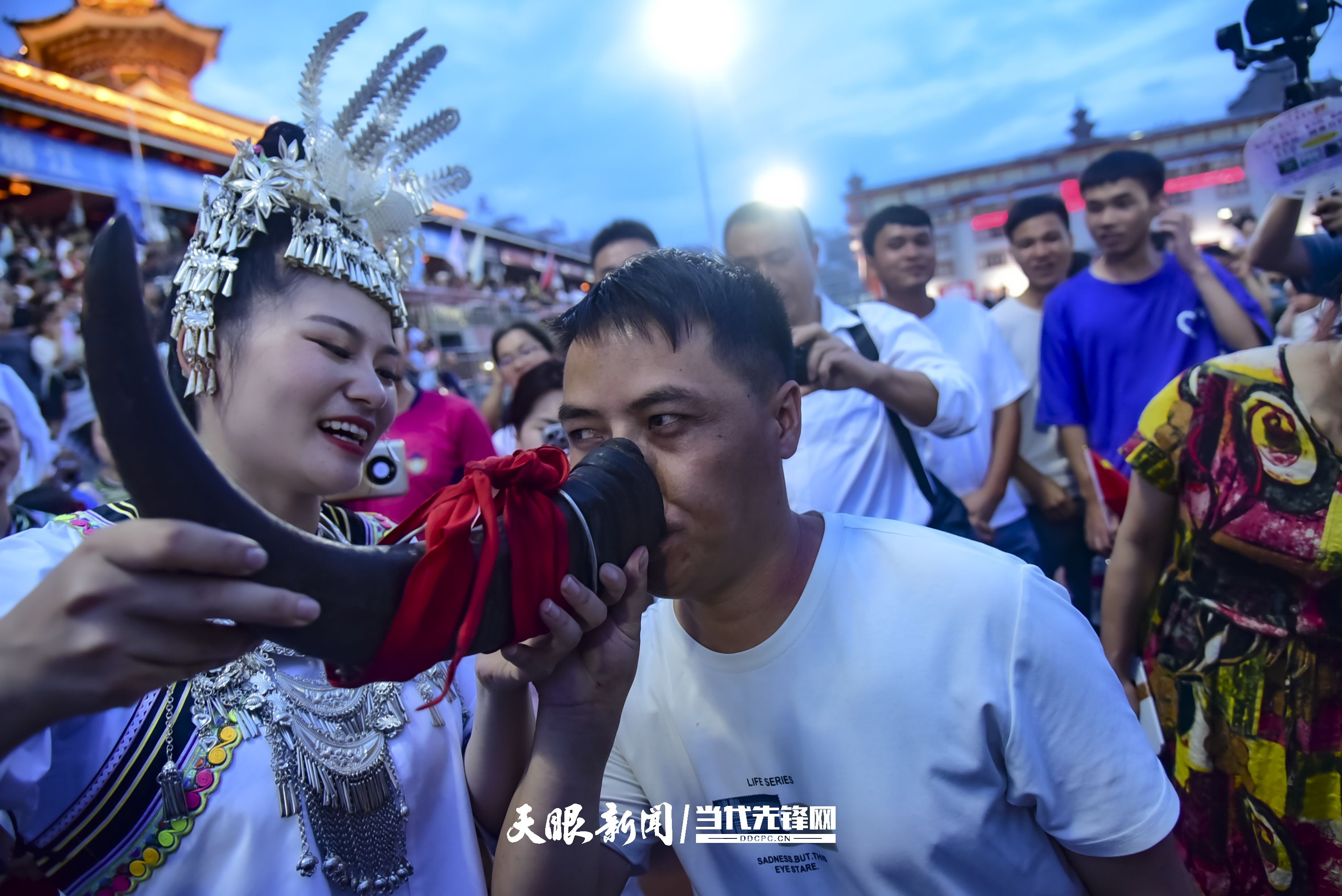 村超現(xiàn)場，當?shù)厝罕娤蜻h道而來的游客敬酒。 潘邵平 攝.jpg